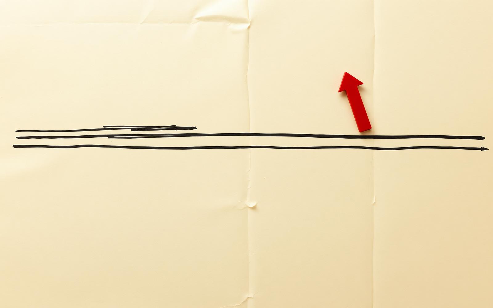 A flat horizontal line on crumpled paper with a tiny red arrow